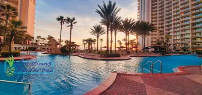 a large swimming pool with palm trees and buildings at Shores of Panama 2028 - Luxurious Gulf-Front 3 Bedroom 3 Bath Sleeps 10 condo in Panama City Beach