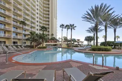 a swimming pool at a resort with chairs and a building at Shores of Panama 2028 - Luxurious Gulf-Front 3 Bedroom 3 Bath Sleeps 10 condo in Panama City Beach
