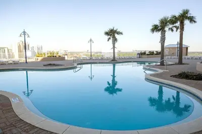 a large blue swimming pool with palm trees in the background at Blissful Sunset at Laketown Wharf #1312 by Nautical Properties in Panama City Beach