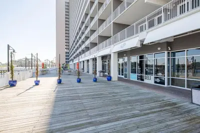 an empty building with blue potted plants on a boardwalk at Blissful Sunset at Laketown Wharf #1312 by Nautical Properties in Panama City Beach