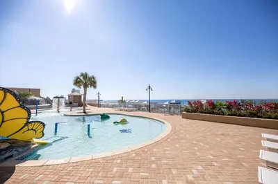 a large swimming pool with the ocean in the background at Laketown Wharf #828 by Nautical Properties in Panama City Beach