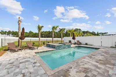 a swimming pool with patio furniture and a fence at Pet Friendly Beach House - Sugary Sands by Panhandle Getaways in Panama City Beach