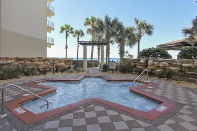 a swimming pool in front of a building with palm trees at Shores of Panama 2026 - 1 BedroomBunksSleeps 6, Res, Parking! condo in Panama City Beach