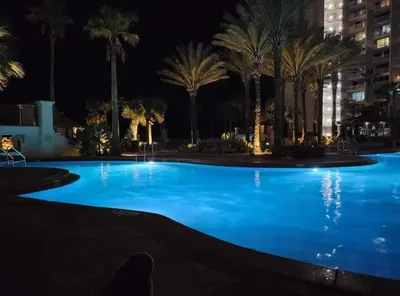 a large swimming pool with palm trees at night at Shores of Panama 1418 - 2 BedroomBunkroom Sleeps8! Updated with a View! Free Fun! condo in Panama City Beach