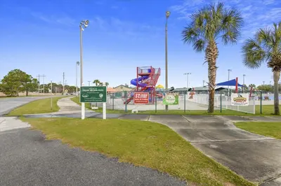 a park with a playground with a slide and palm trees at Shores of Panama 1418 - 2 BedroomBunkroom Sleeps8! Updated with a View! Free Fun! condo in Panama City Beach