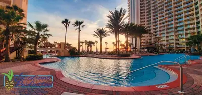 a large swimming pool with palm trees and buildings at Shores of Panama 707 - 2 BedroomBunks Sleeps 8, Reserved Parking Free Fun! condo in Panama City Beach
