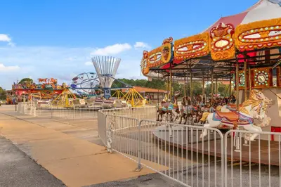 a carousel at a carnival with a roller coaster at Stunning 2/2 Designer Condo w Coastal Appeal Right on the Gulf! in Panama City Beach