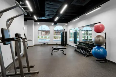 a gym with cardio equipment in a room with windows at Calypso 3-903 - Emerald Getaway in Panama City Beach