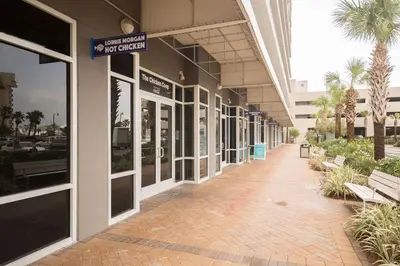 a hallway of a building with benches and palm trees at Laketown Wharf #1006 by Nautical Properties in Panama City Beach
