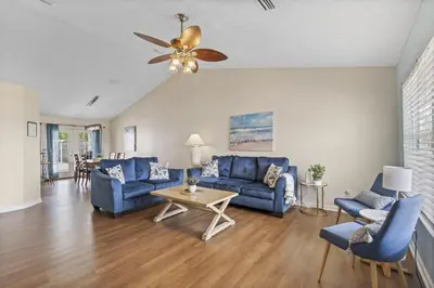 a living room with blue furniture and a ceiling fan at The Splash Pad Sleeps 13 w Pool Patio and Garage in Panama City