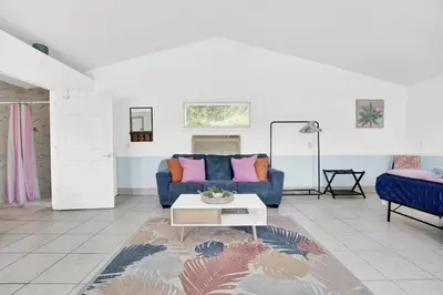 a living room with a blue couch and a table at The Splash Pad Sleeps 13 w Pool Patio and Garage in Panama City