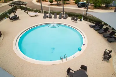an overhead view of a large swimming pool with chairs at Pelican House - Newly remodeled, professionally decorated, only about 1 mile to Seaside! in Santa Rosa Beach