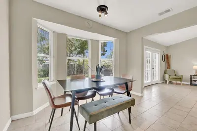 a dining room with a table and chairs and windows at Two Spaces in One Main House and Guest House 25 Min to PCB in Panama City