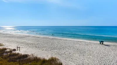 a person standing on a beach with an umbrella at BeachCrest 501 in Santa Rosa Beach