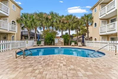 a swimming pool in a courtyard with palm trees at Merrimac Resort #31 in Panama City Beach