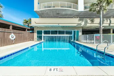a swimming pool with blue water in a building at Ocean Villa 1605 in Panama City Beach