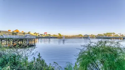 a large body of water with a pier and buildings at The Beach Scene at Laketown Wharf #524 by Nautical Properties in Panama City Beach