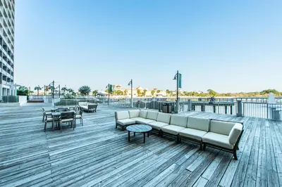 a couch on a boardwalk with tables and chairs at Laketown Wharf 2018 in Panama City Beach