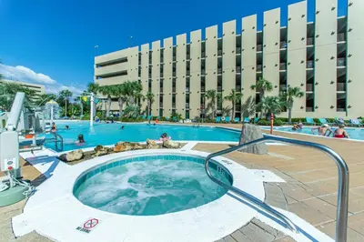 a large swimming pool with a hot tub in front of a building at Emerald Beach 930 in Panama City Beach