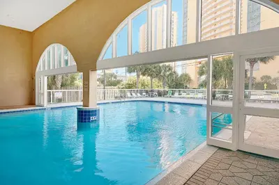 a large swimming pool in a building with windows at Celadon 302 in Panama City Beach
