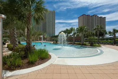 a swimming pool with a fountain in a resort at Emerald Beach Resort 2235 in Panama City Beach