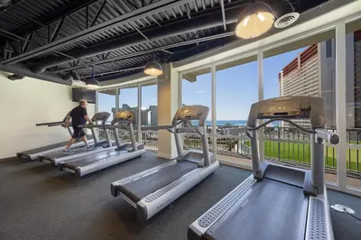 a man walking on treadmill in a gym with windows at Laketown Wharf #1025 in Panama City Beach