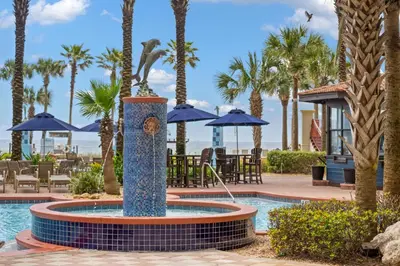 a fountain in the middle of a pool with palm trees at Shores Of Panama #1412 in Panama City Beach