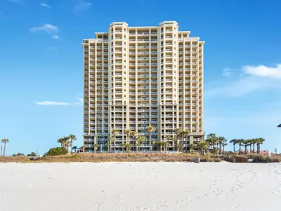 a tall building on the beach next to the ocean at Grand Panama Beach Resort - The Grand #704 in Panama City Beach