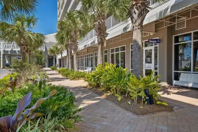a walkway in front of a building with palm trees at Laketown Wharf #1824 in Panama City Beach