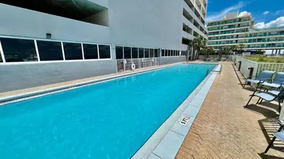 a large blue swimming pool in a building at Ocean Reef 1904 in Panama City Beach