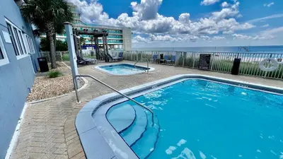 a swimming pool with the ocean in the background at Ocean Reef 1608 in Panama City Beach