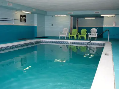 a swimming pool with chairs and chairs in a building at Ocean Reef 1609 in Panama City Beach