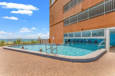 a swimming pool in front of a building at Tropic Winds 1806 in Panama City Beach