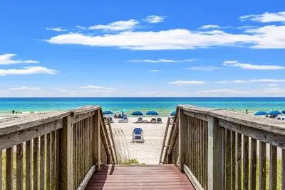 a boardwalk leading to the beach with umbrellas at Tropic Winds 2002 in Panama City Beach