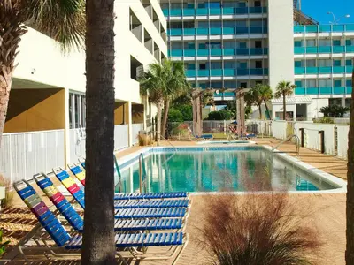 a swimming pool with lounge chairs and a building at Ocean Reef 1101 in Panama City Beach
