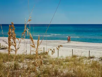 a couple of people walking on the beach at Ocean Reef 1604 in Panama City Beach
