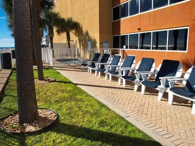 a row of lounge chairs in front of a building at Tropic Winds 1903 in Panama City Beach