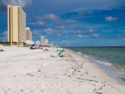 a group of people on a beach near the ocean at Tropic Winds 603 in Panama City Beach