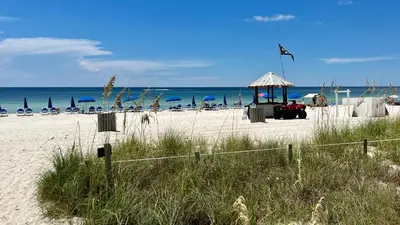 a beach with a gazebo and chairs and the ocean at Ocean Reef 1902 in Panama City Beach