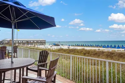 a patio with a table and chairs and the beach at Shores Of Panama #2101 in Panama City Beach