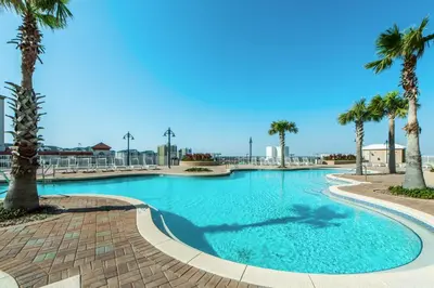 a swimming pool with palm trees in a resort at Laketown Wharf 1120 by Emerald Coast Retreats in Panama City Beach