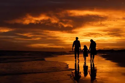 a family walking on the beach at sunset at Pura Vida in Watersound Beach