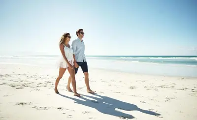 a man and a woman walking on the beach at WaterHouse 401 in Seacrest
