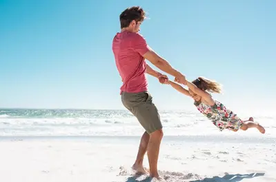 a man and a girl playing in the sand on the beach at 28 Beach Bike Way in Santa Rosa Beach