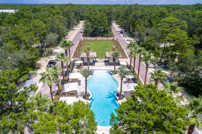 an aerial view of a resort pool with palm trees at 30A Magnolia Cottages by the Sea by Panhandle Getaways in Seacrest