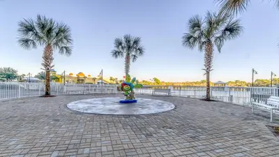 a fountain in a park with palm trees at Laketown Wharf #1734 by Nautical Properties in Panama City Beach