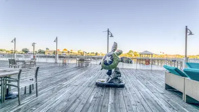 a statue on a boardwalk with tables and chairs at Laketown Wharf #1734 by Nautical Properties in Panama City Beach