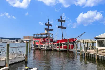 a red boat is docked at a dock at Sunshine House! 3BR 2BA Sleeps 9! Your perfect retreat for comfort and style in Panama City