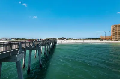 a pier over the ocean with a beach in the background at Laguna Haven! 3BR 2BA Sleeps 7! Your perfect escape! in Panama City Beach