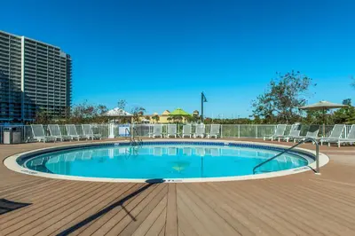 a swimming pool on a deck with chairs around it at Laketown Wharf 801 by Emerald Coast Retreats in Panama City Beach